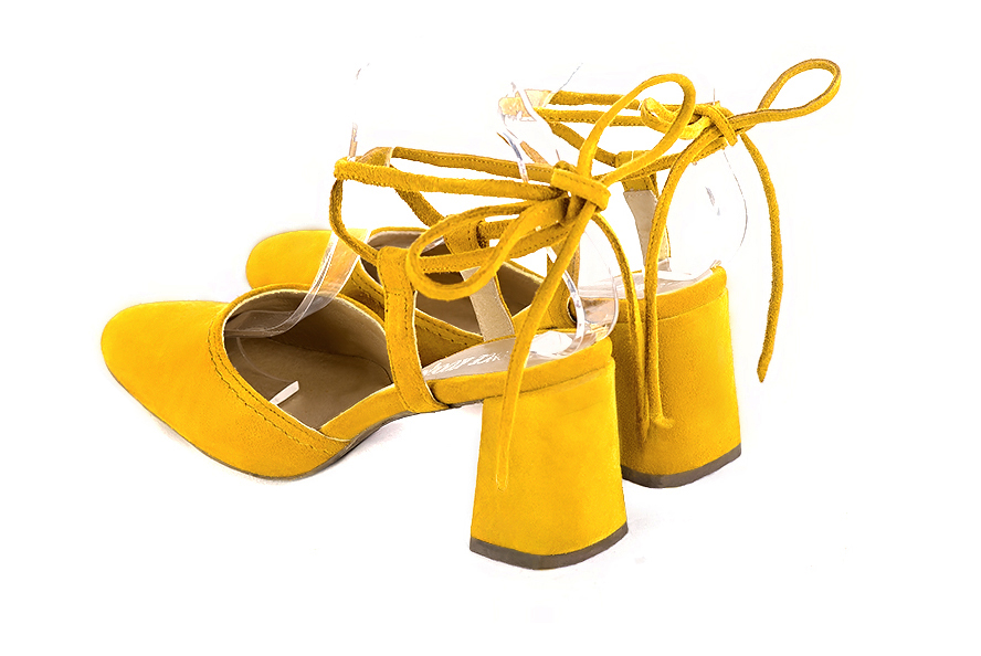 Women's yellow elegant closed-toe heels, with crossed straps. Round toe. High flare heels - Rear view